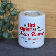 A personalised white ceramic candle holder with a message in red lettering and green stars.